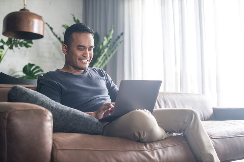 Man looking at a computer in his couch