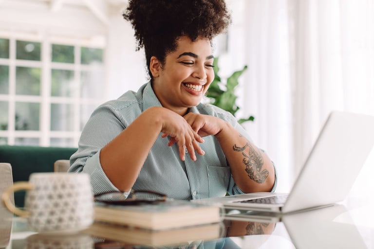 African American Women Laughing While Looking at a Computer Screen