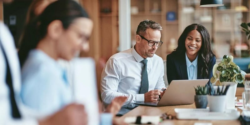 Two business people looking at a computer in front of them