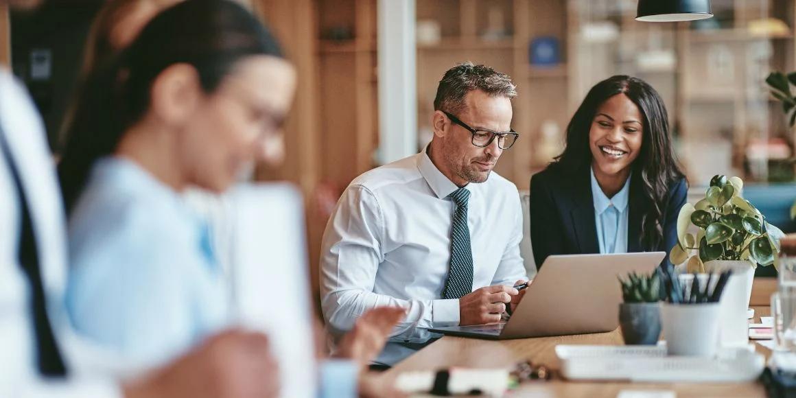 Two business people looking at a computer in front of them