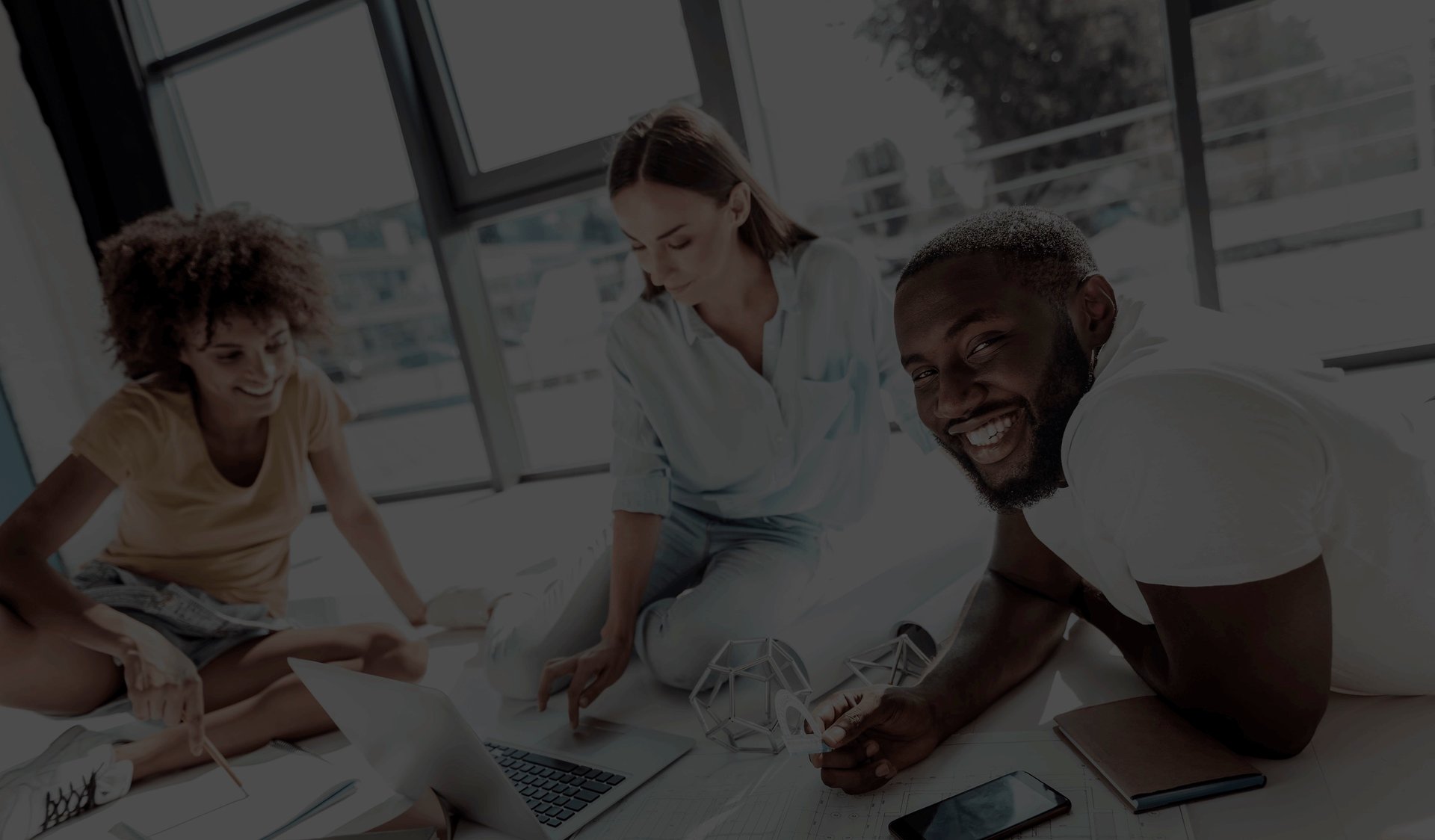 Employees working at a desk together and smiling