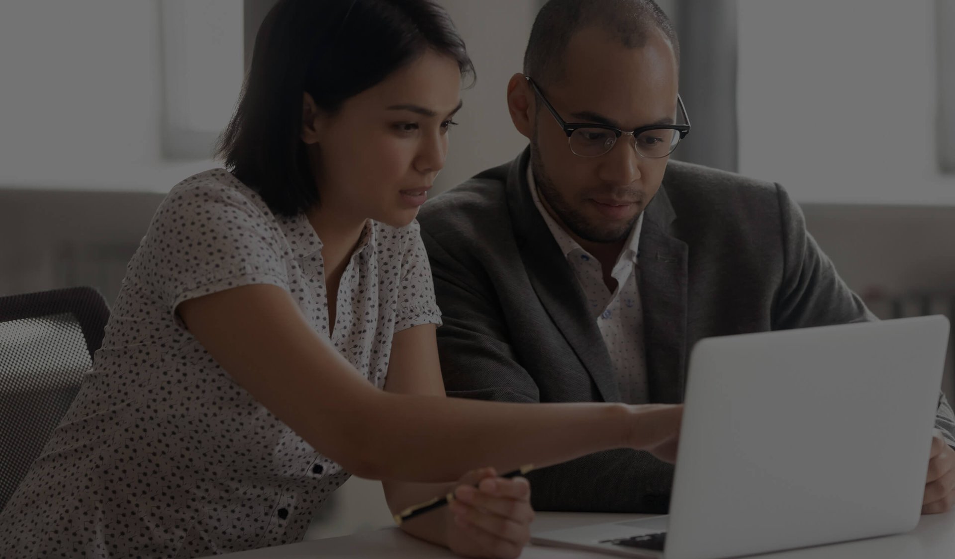Two employees working at a laptop