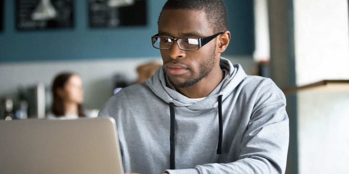 African American man looking at his laptop in a coffee shop