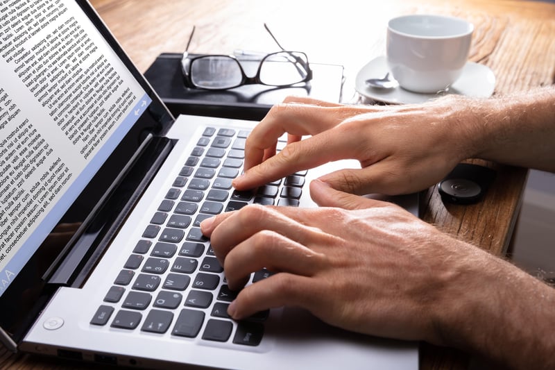 Man typing on laptop using Hubspot content assistant 