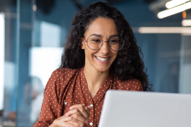 b2b female executive leader investing in her personal branding, writing linkedIn posts on her laptop