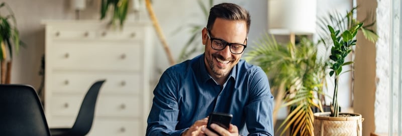 Businessman using a mobile phone while being at the office.