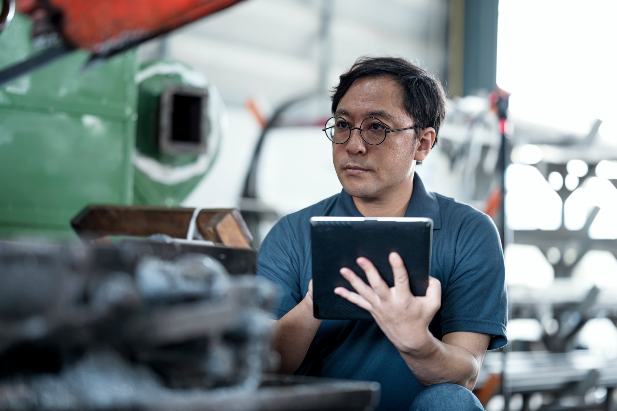 Analyzing Machine Failures in a Production Process. Shot of Senior Maintenance Engineer using machine monitoring software to check status, workload, downtime, and utilization to improve productivity in production process.