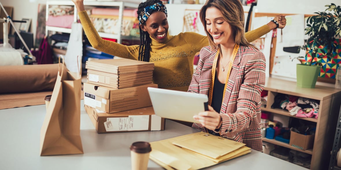 Two marketers looking at a tablet while smiling