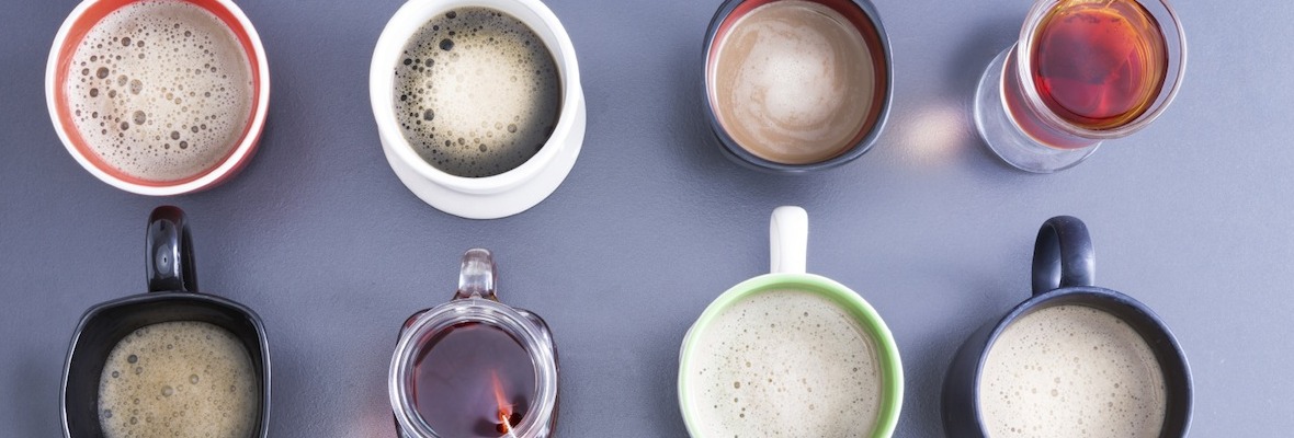 Different sizes and colors of cups with coffee