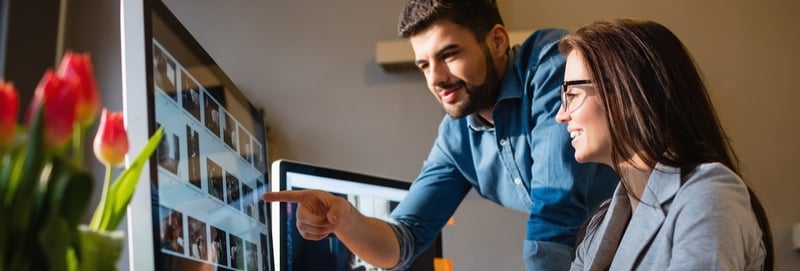 Graphic designer pointing at monitor