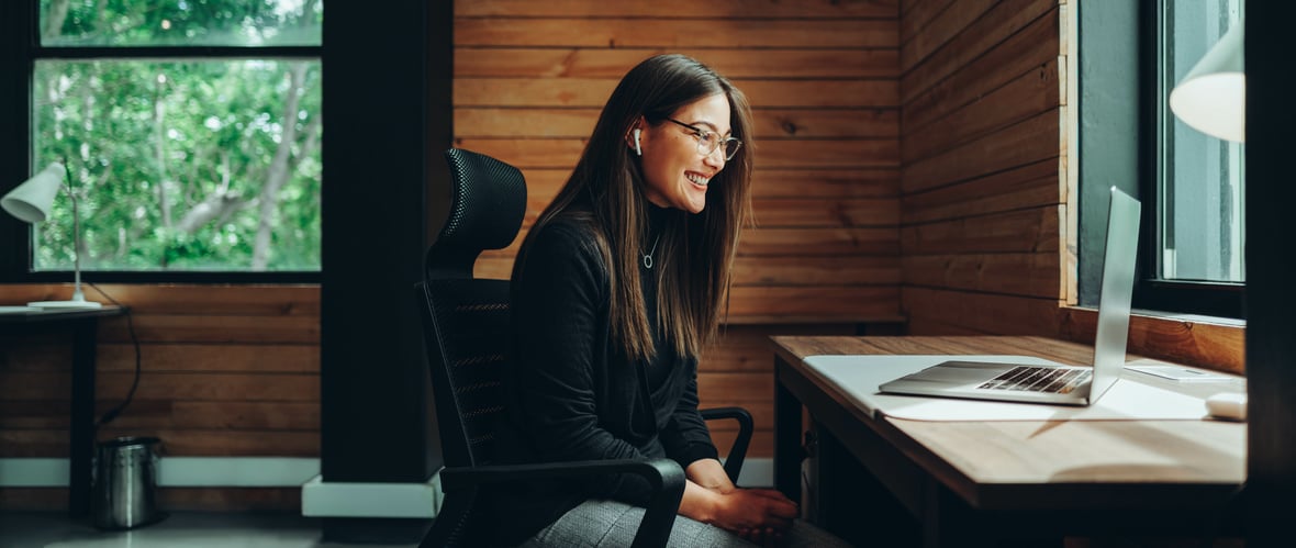 A woman review AI-built content marketing tools on a computer in an office. 