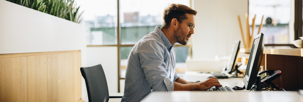 A man reviews HubSpot's new workflow features on a laptop. 