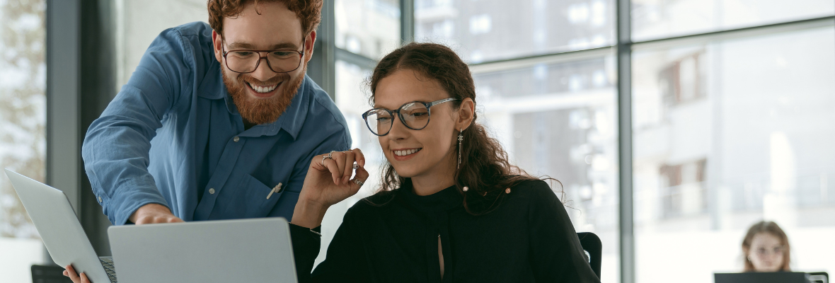 Two customer success representatives analyze customer feedback on a computer. 