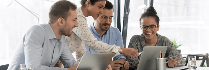 A group of employees review HubSpot's Operations Hub on a laptop. 