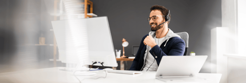 A man watches a webinar on a desktop computer.