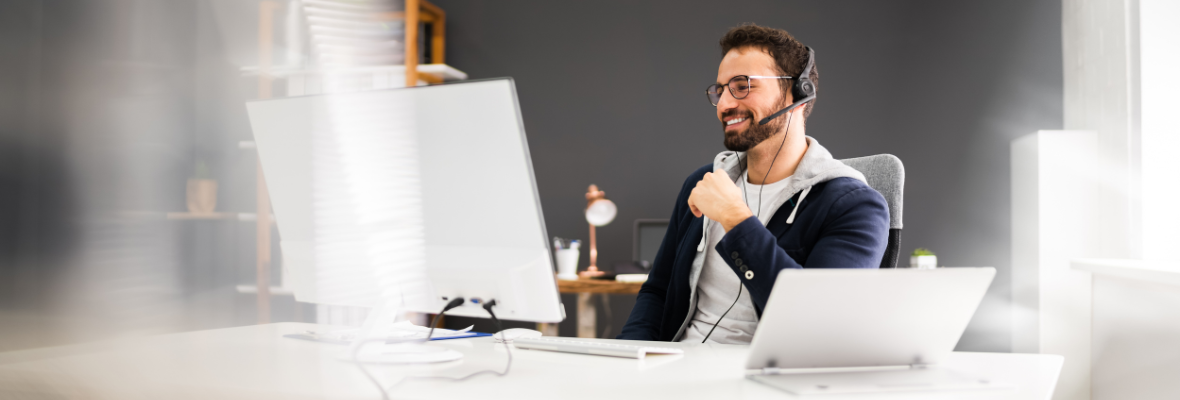 A man watches a webinar on a desktop computer.