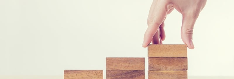 Hands creating columns with wooden pieces