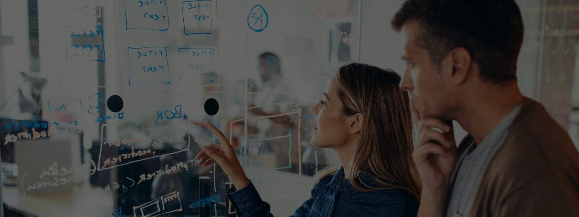 Two people looking at a whiteboard