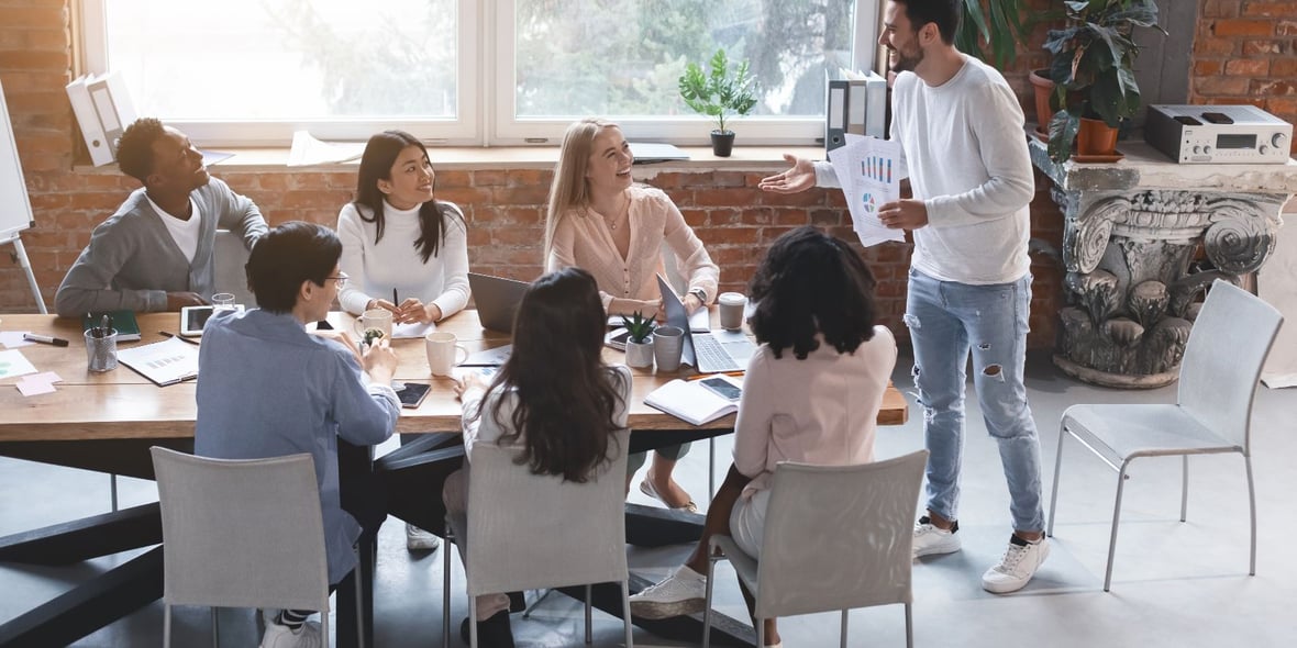 A group of marketers sitting down while looking at their manager show them some metrics