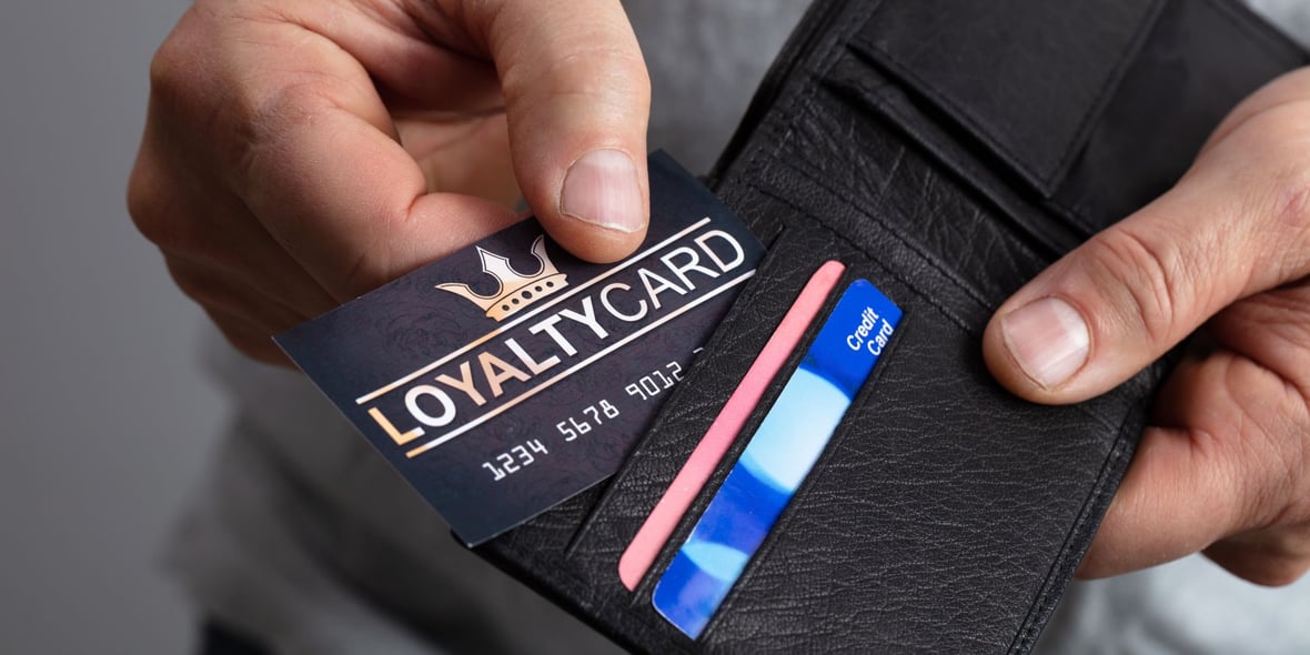 Close up image of a hand taking out a loyalty program card from wallet