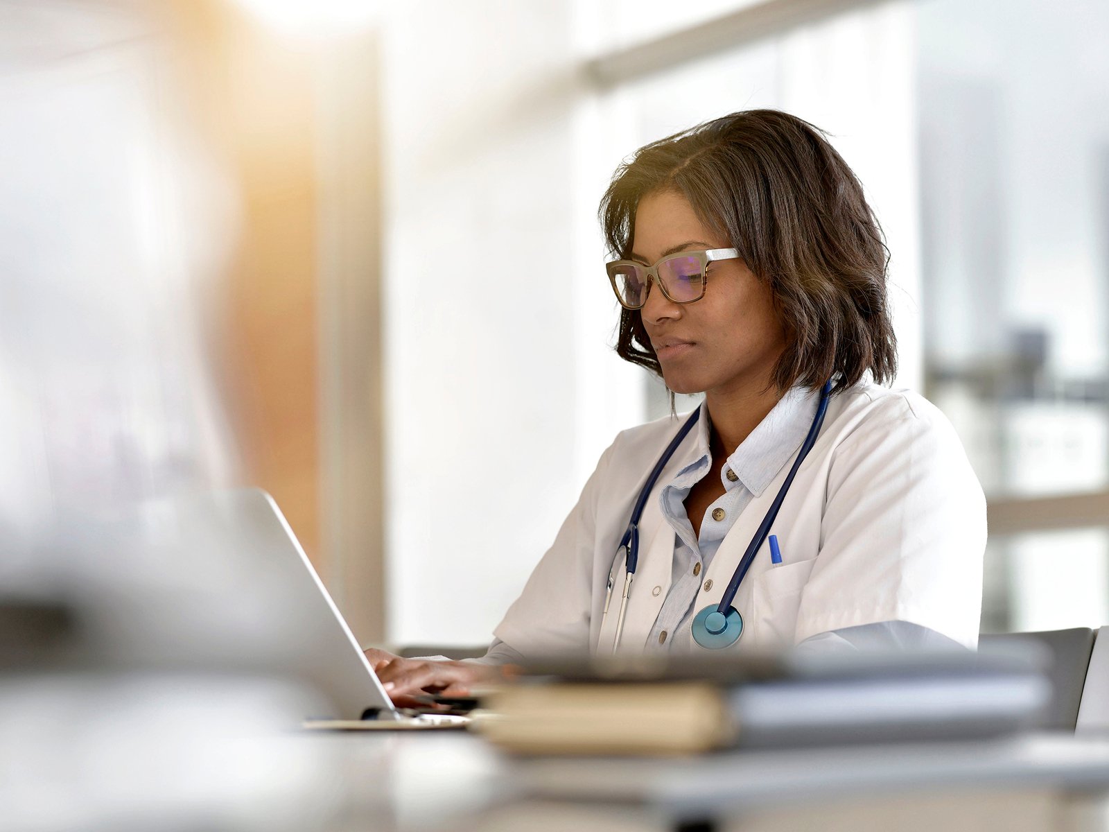 Doctor at her office looking at a laptop