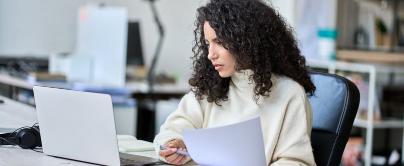 Woman sitting at a desk looking at her laptop
