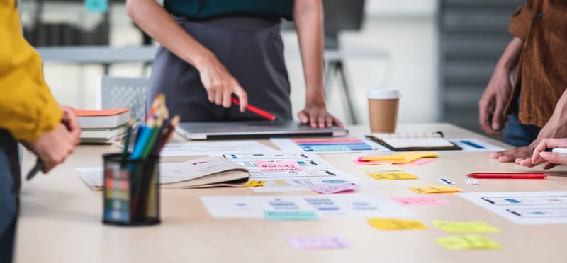 A healthcare marketing team brainstorming patient engagement strategies around a table covered in sticky notes.