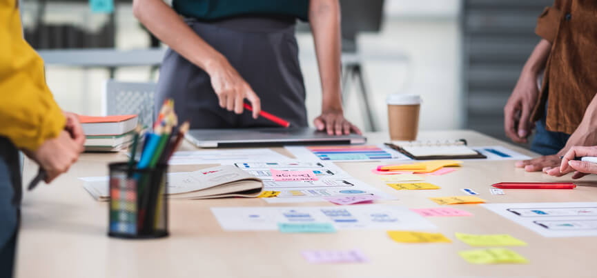 A healthcare marketing team brainstorming patient engagement strategies around a table covered in sticky notes.