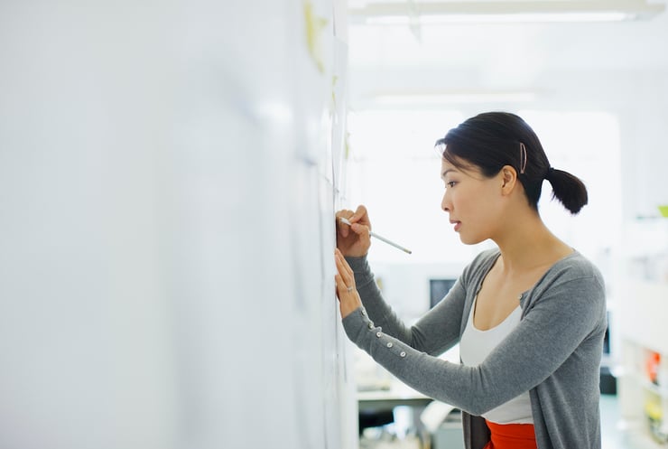 person writing on a white board