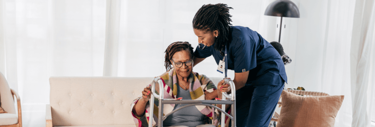An elderly woman in a wheelchair being taken care of by a senior living care-taker