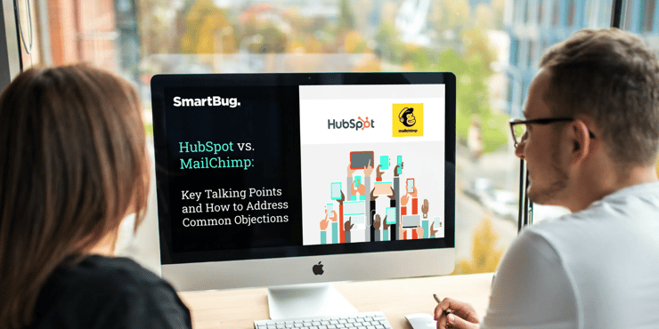 Two individuals looking at HubSpot vs Mailchimp offer on a computer
