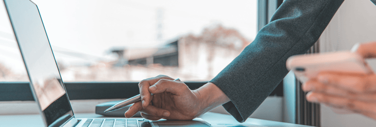 Close up image of two hands working on a laptop