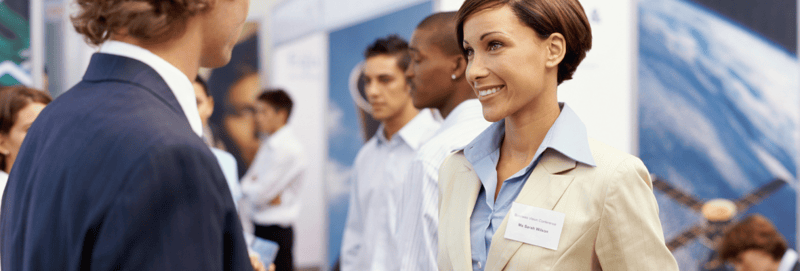 Two business people smiling at each other at a tradeshow