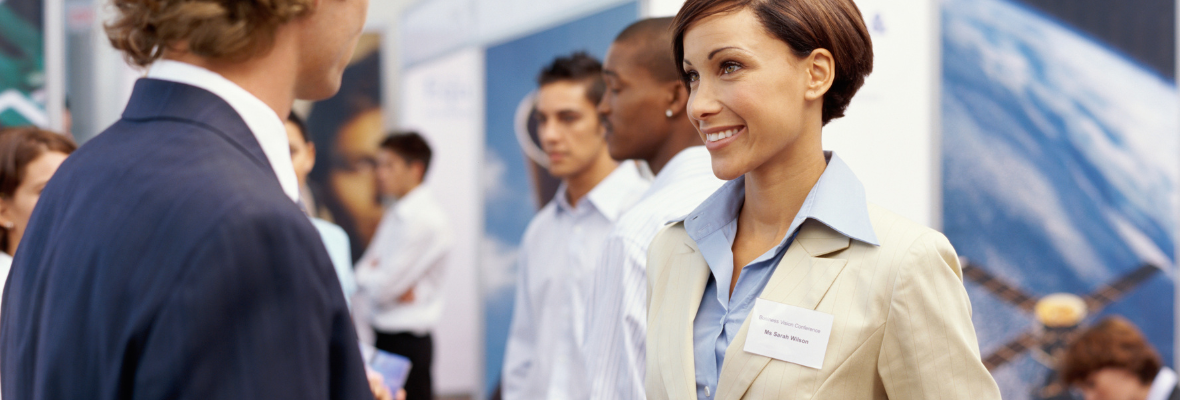 Two business people smiling at each other at a tradeshow