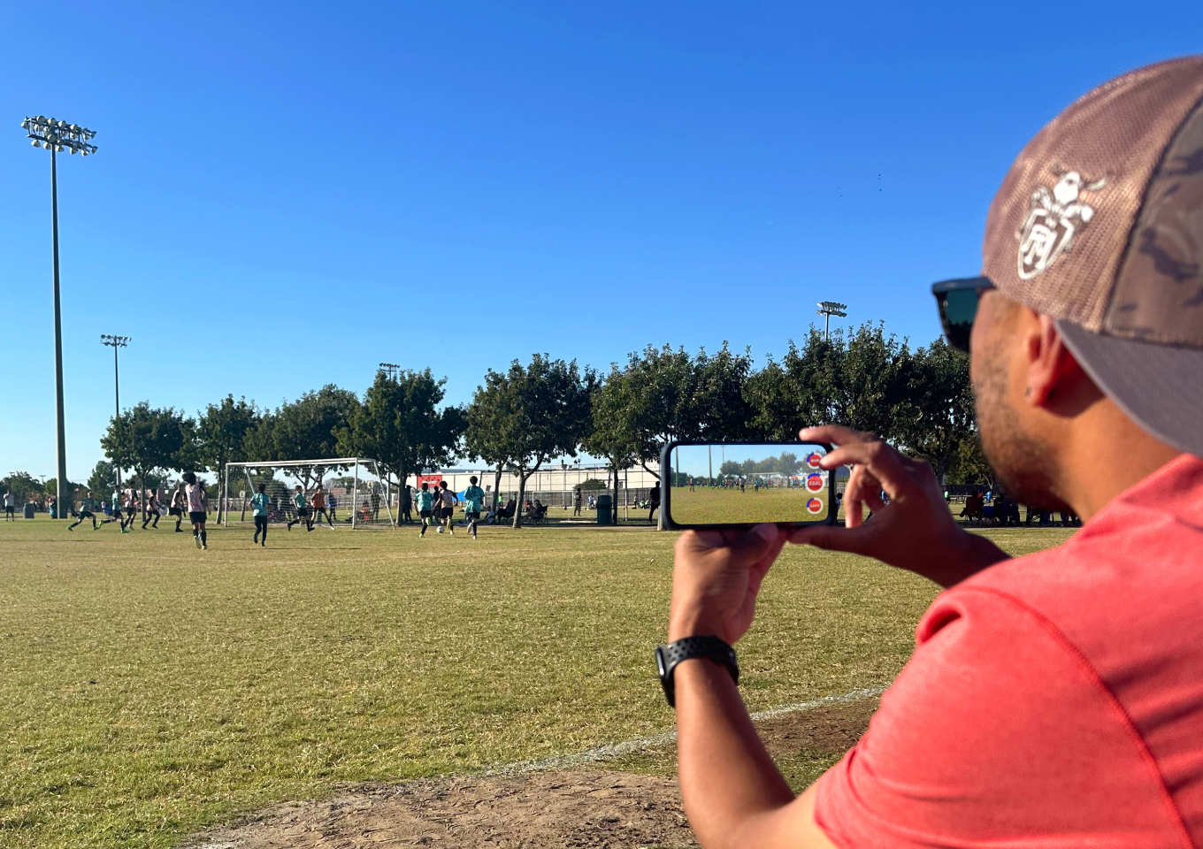 man recording a soccer match with his phone