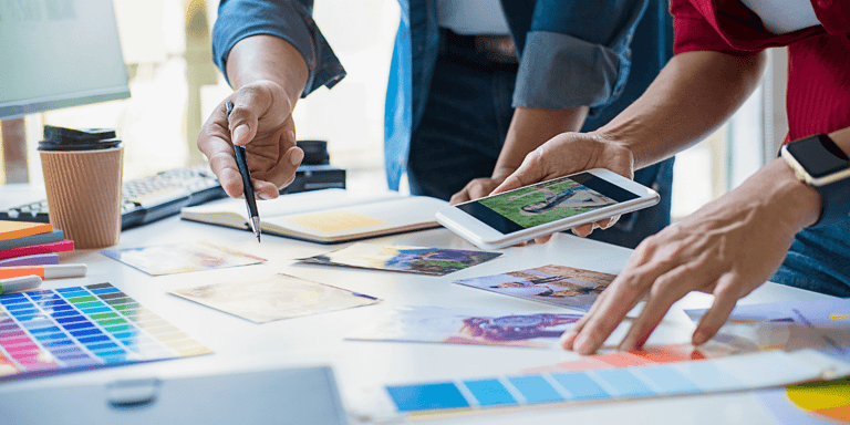 Close up image of hands working at a table selecting different design elements