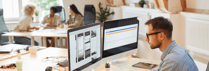 A marketer working on a CRM integration on two screens