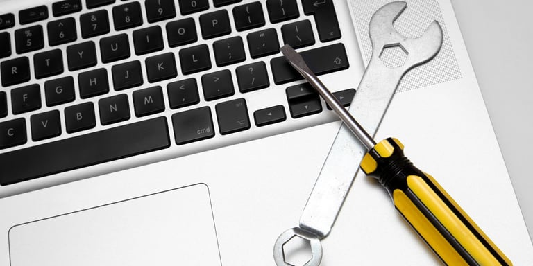 Close up image of a laptop keyboard with a few tools on top of it