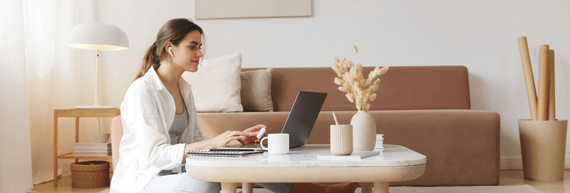 Woman sitting working on a coffee table