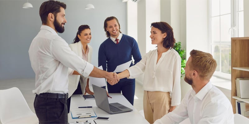 A woman shaking the hand of an investor while smiling