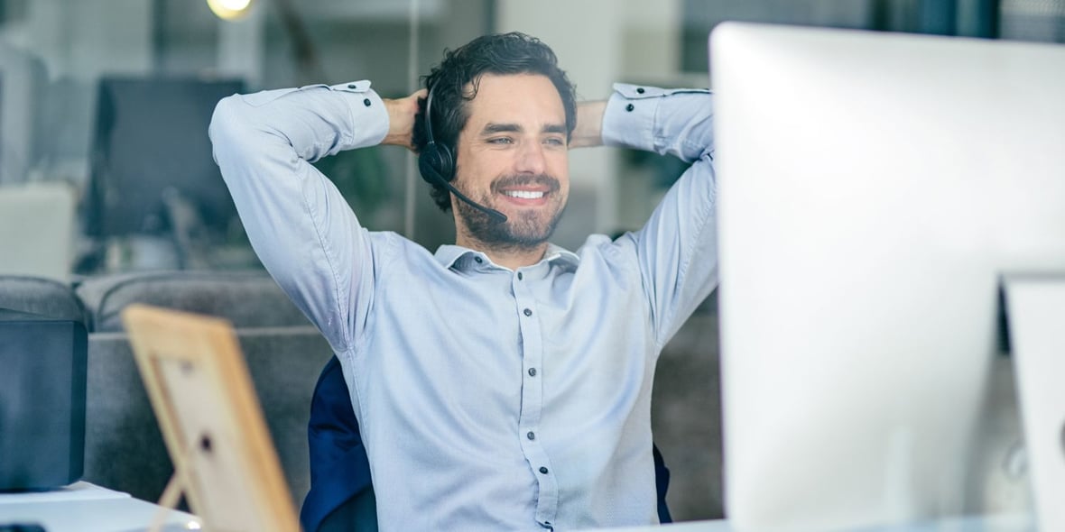 Man smiling and looking at his computer as in a satisfied manner