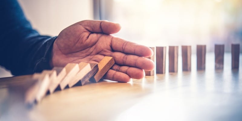 Image of a hand stopping a few pieces from falling