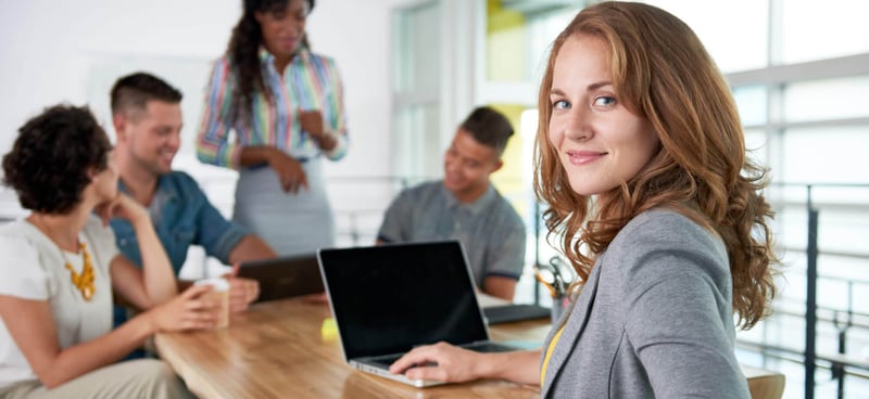 viaPeople Banner Image people talking at a desk with laptop open and woman smiling