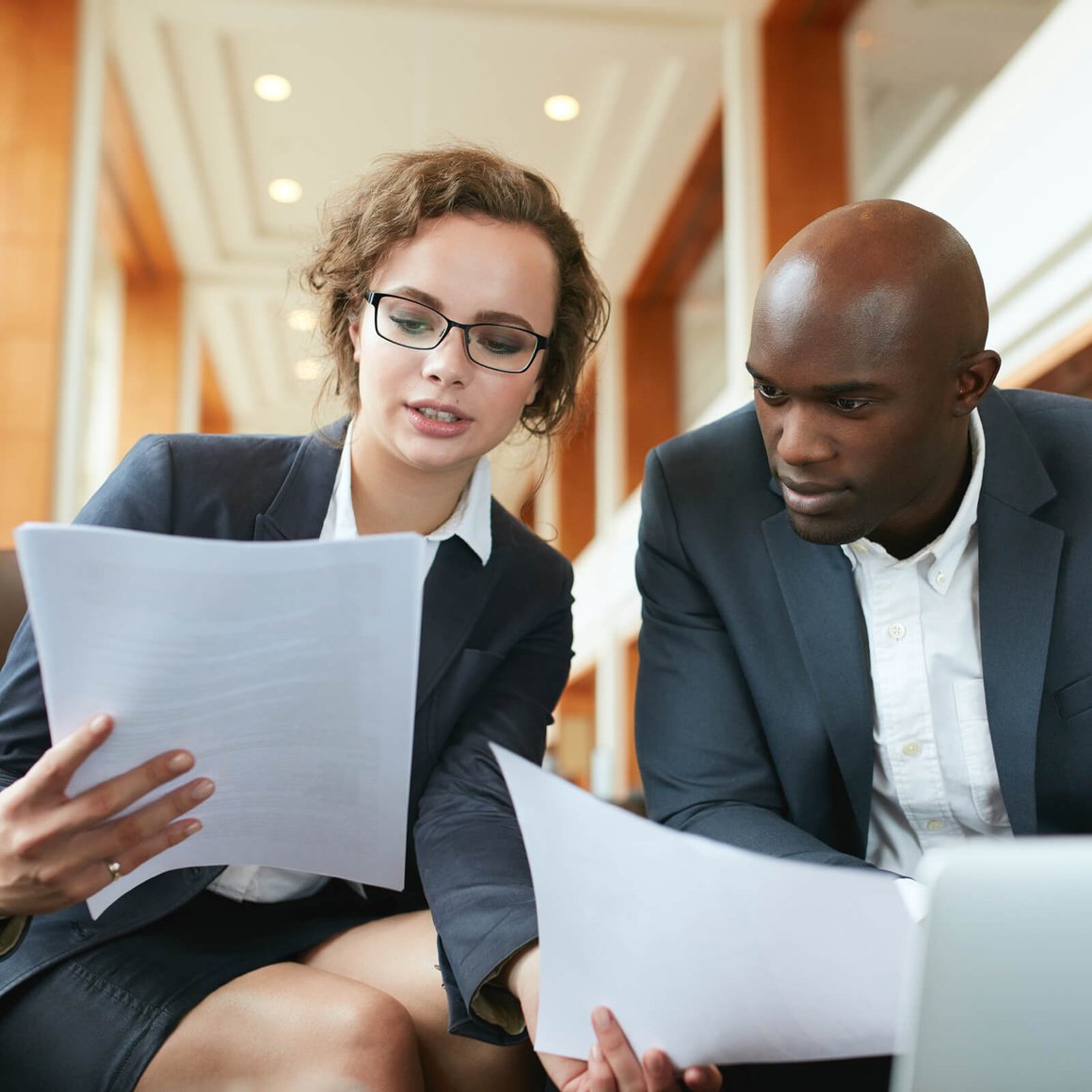 Two people examining printed documents