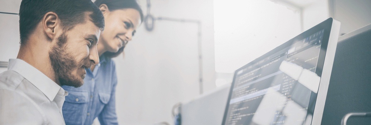 Man and woman looking at computer analyzing data on the screen