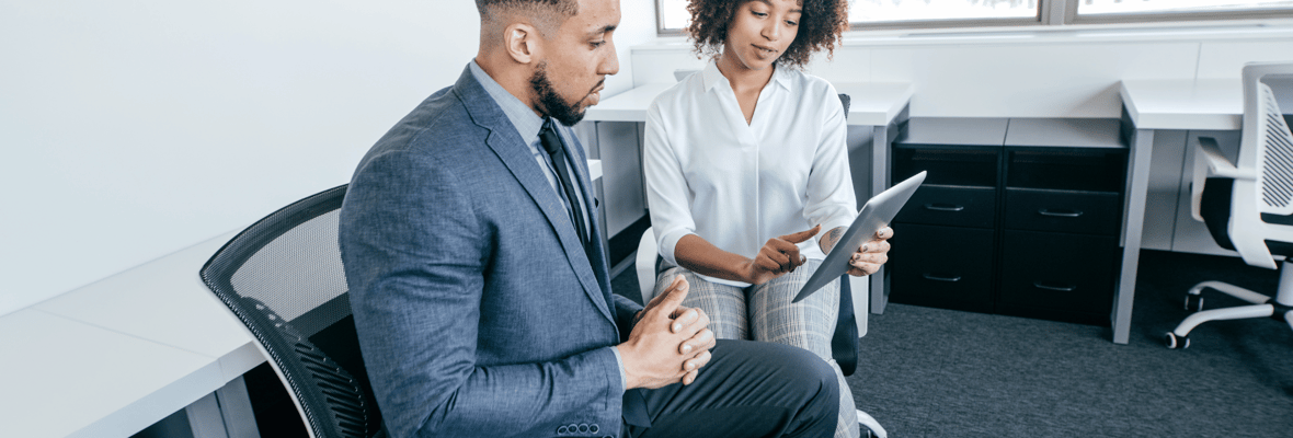 Two marketers sitting and looking at an tablet