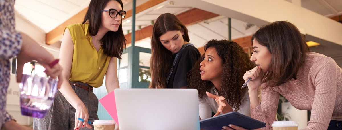 Group of people surrounding a laptop