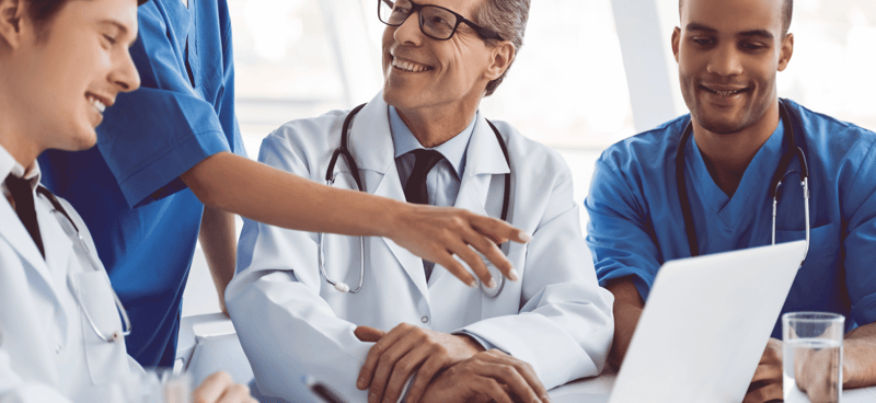 Doctor and nurse pointing at laptop screen, Akinox Case Study SmartBug Media