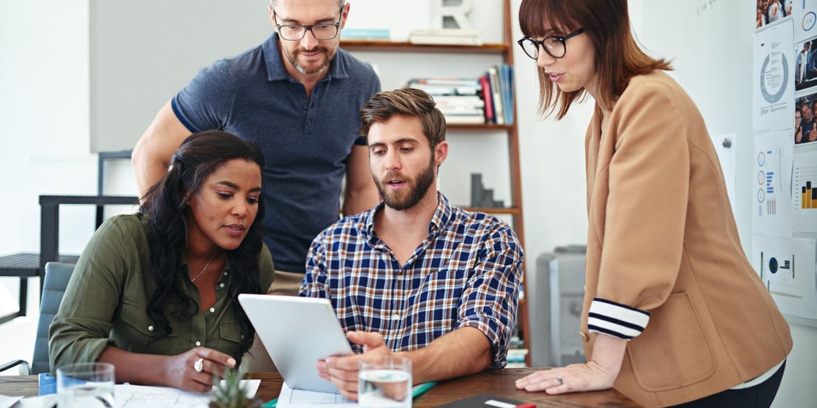 Four marketing & sales professionals discussing at an office table