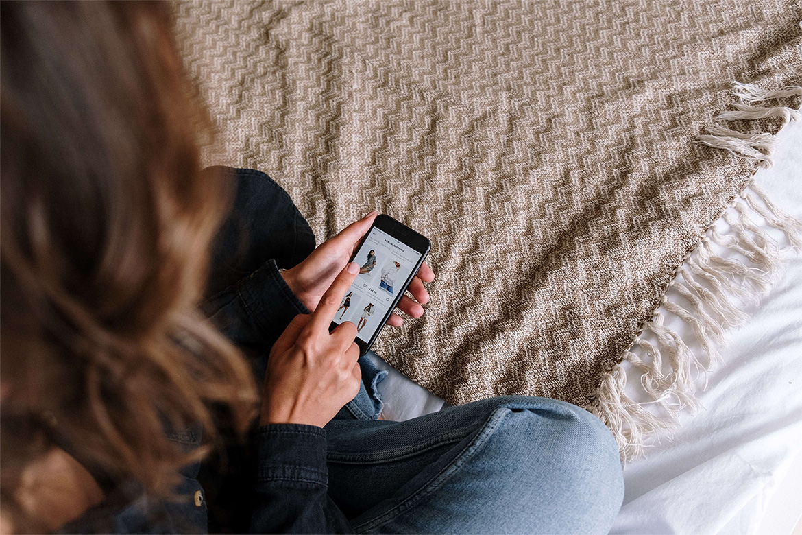 close up image of a woman looking at a product page on her Iphone